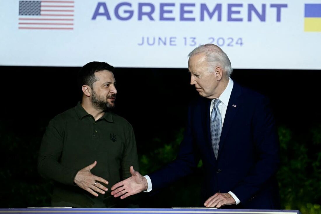 O presidente ucraniano Volodymyr Zelensky (esq) e o presidente dos EUA Joe Biden apertam as mãos após assinarem um acordo bilateral de segurança 