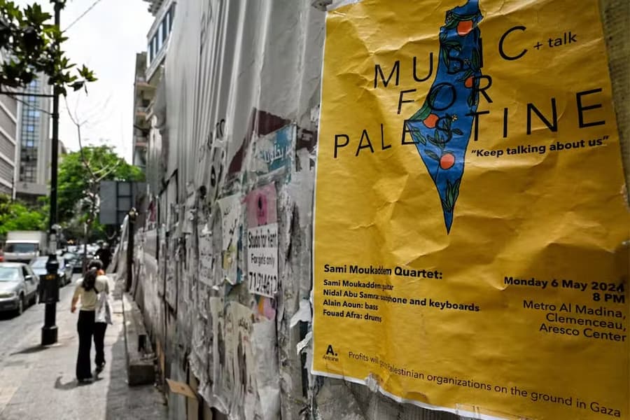 Anúncio de um concerto musical em solidariedade com a Palestina é exibido ao longo de um muro na rua Hamra, em Beirute, a 20 de junho de 2024. 