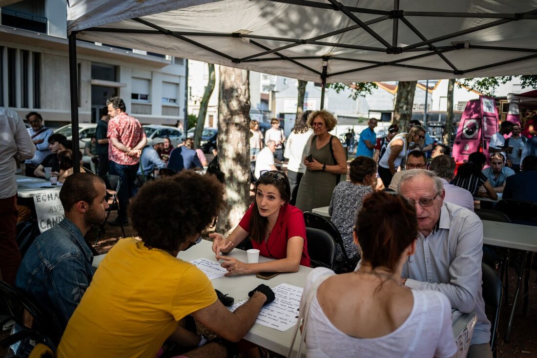 Partido político francês Europa-Ecologie-Les Verts (EELV) e candidato da coligação "Nouveau Front Populaire" (NFP) para as próximas eleições legislativas Marie-Charlotte Garin (C) conversa com militantes antes de uma reunião do NFP em Lyon