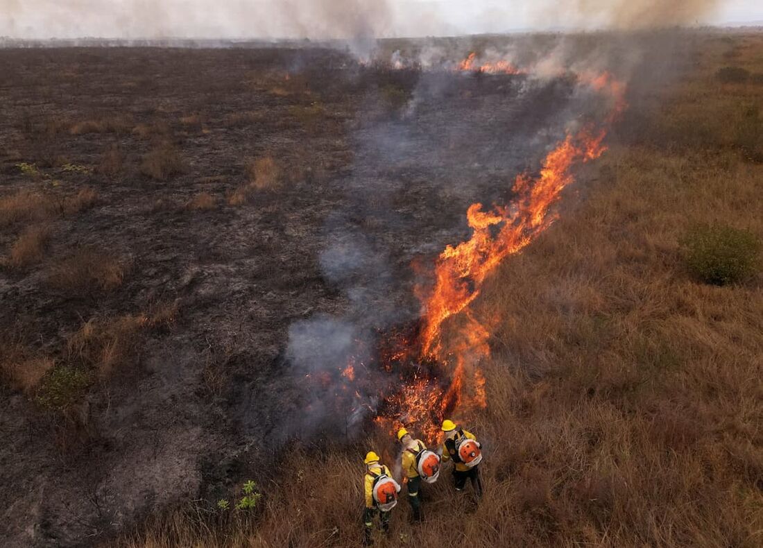  bombeiros trabalhando em um foco de incêndio em uma área rural de Corumbá, porta de entrada para o Pantanal brasileiro