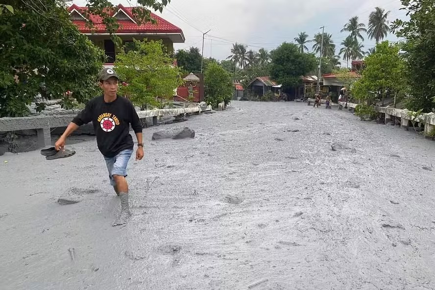 Residente atravessa lahar da erupção do vulcão Monte Kanlaon ao longo de uma estrada na vila de Biaknabato no município de La Castellana