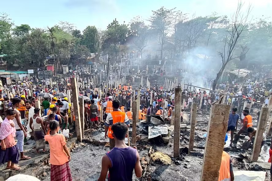 Refugiados observam os escombros de suas casas carbonizadas após ataque no campo de Ukhia 