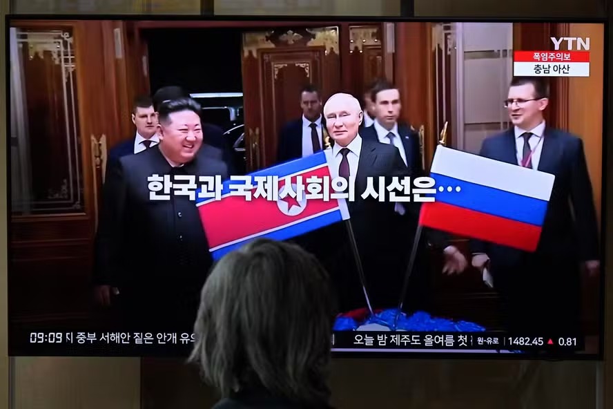 Noticiário na TV mostra o líder da Coreia do Norte, Kim Jong-un ao lado do presidente russo, Vladimir Putin, durante visita a Pyongyang 