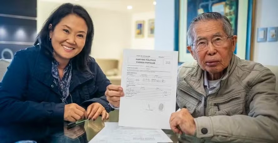 Alberto Fujimori com ficha de filiação do partido Força Popular, ao lado da filha Keiko Fujimori 