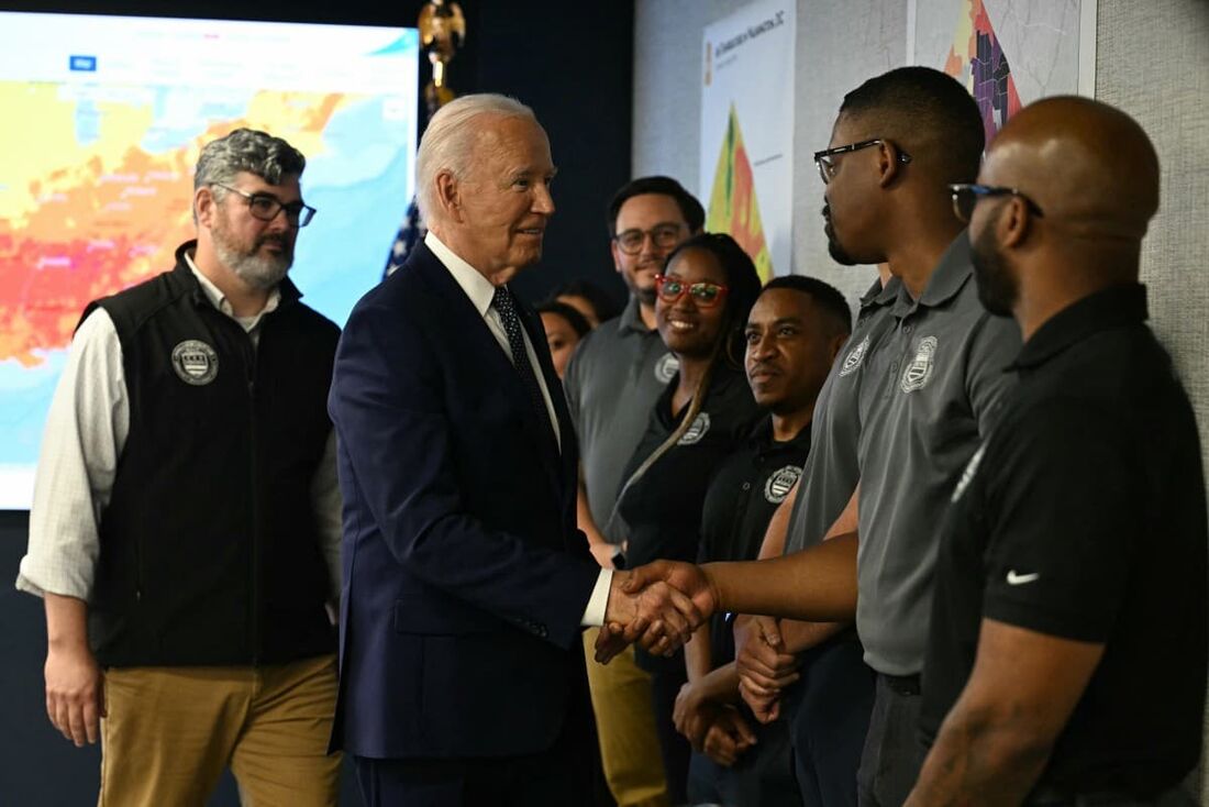 O presidente dos EUA, Joe Biden (C), cumprimenta funcionários no Centro de Operações de Emergência de DC em Washington