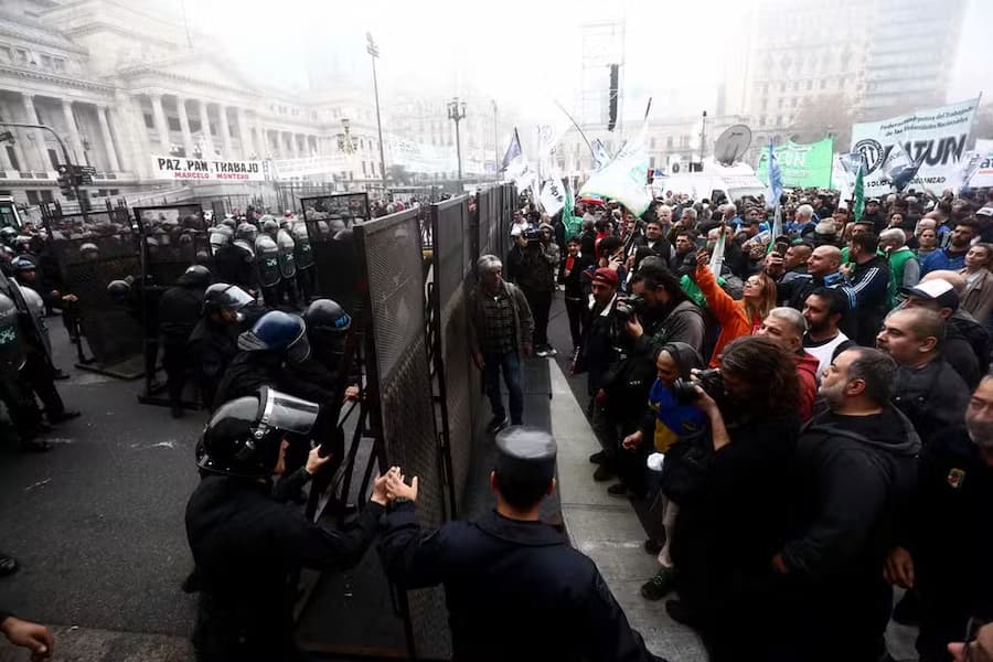 Polícia cria barreira em frente a manifestantes em frente ao Congresso argentino durante votação da Lei de Bases 