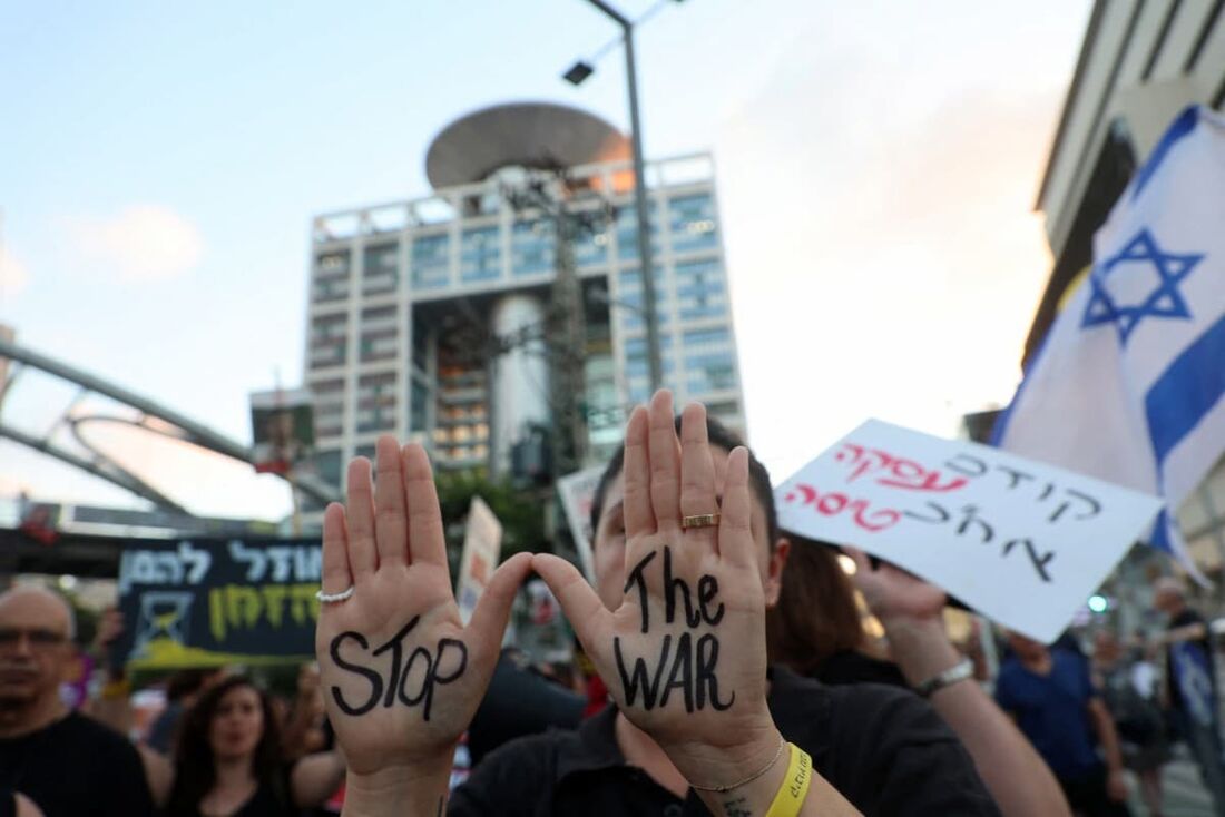 Uma manifestante mostra uma mensagem anti-guerra escrita nas palmas das mãos durante uma manifestação pedindo a libertação de israelenses mantidos reféns por militantes palestinos na Faixa de Gaza 