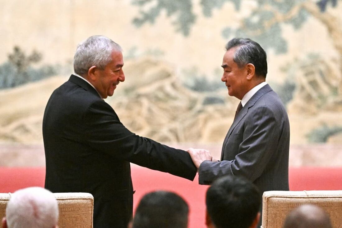 Mahmoud al-Aloul (E), vice-presidente do Comitê Central da organização palestina e partido político Fatah, aperta a mão do ministro das Relações Exteriores da China, Wang Yi