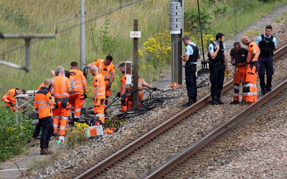 Funcionários da SNCF e gendarmes franceses inspecionam a cena de um suposto ataque à rede ferroviária de alta velocidade em Croiselles, norte da França