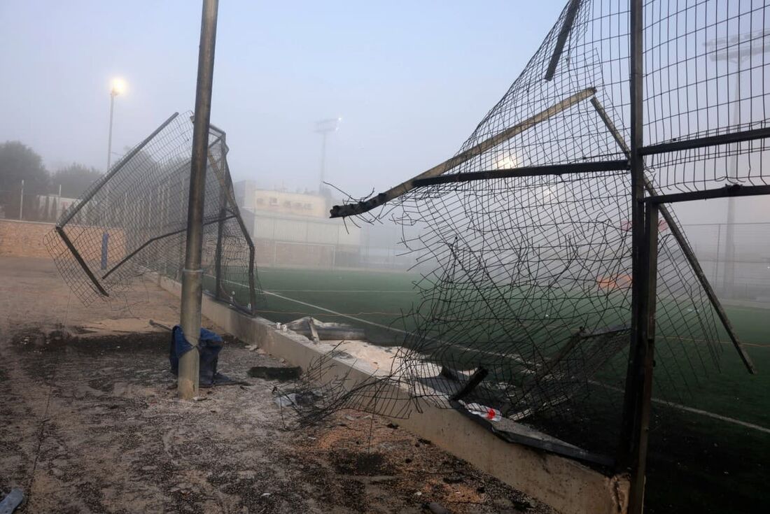 Um portão danificado e destroços são vistos em um campo de futebol após um ataque relatado do Líbano ter caído na vila de Majdal Shams na área de Golã anexada por Israel 