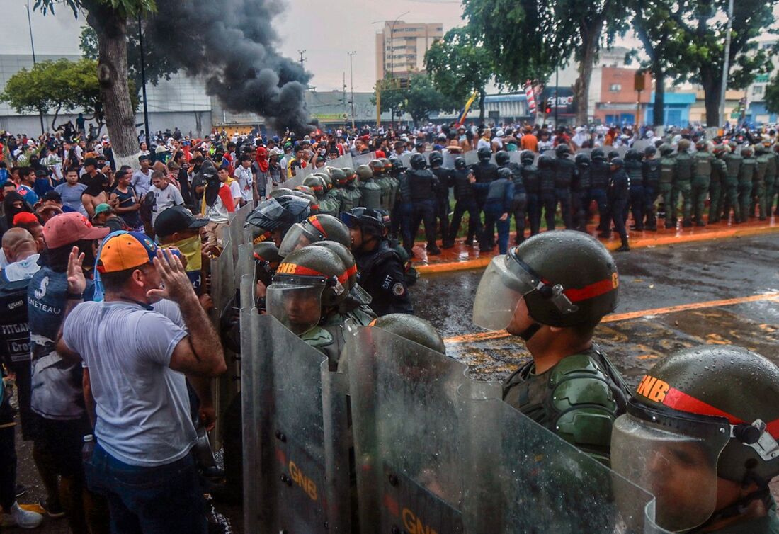 Manifestantes confrontam a polícia de choque durante um protesto contra o governo do presidente venezuelano Nicolás Maduro em Puerto La Cruz, na Venezuela