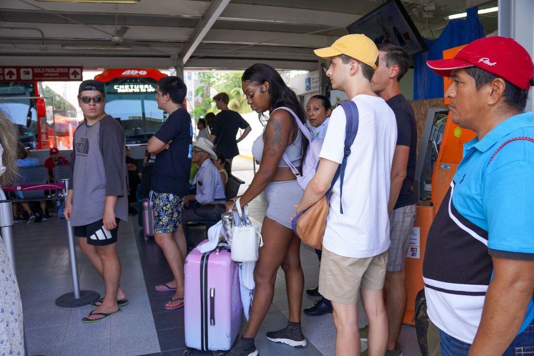 Turistas esperam em um terminal de ônibus para partir para Cancún para escapar do furacão Beryl em Tulum, estado de Quintana Rio, México