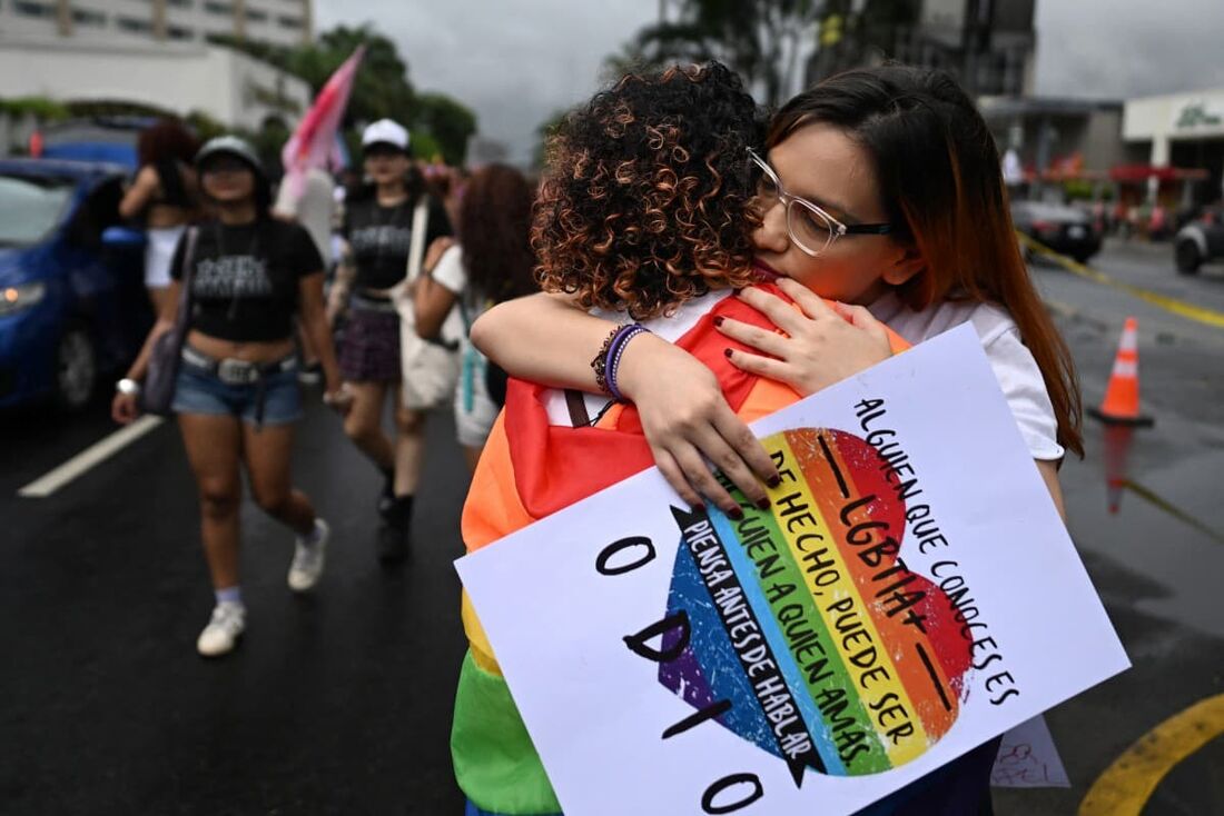 Fiorella Turchkeim (E) e Andrea Ordoñez se abraçam na Parada do Orgulho em San Salvador 