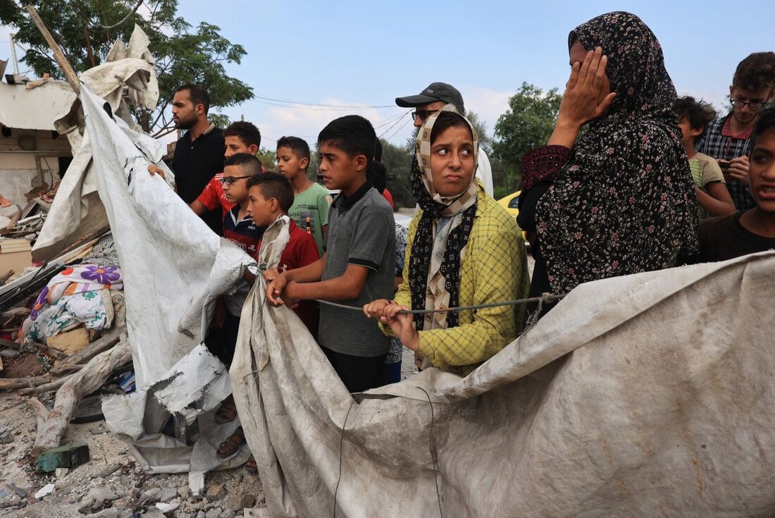 Palestinos checam casa destruída após bombardeio israelense