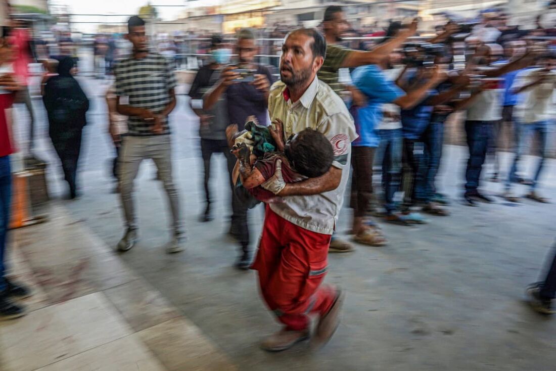 Um paramédico carrega uma criança ferida durante o bombardeio israelense para a ala de emergência do hospital Nassr em Khan Yunis, no sul da Faixa de Gaza