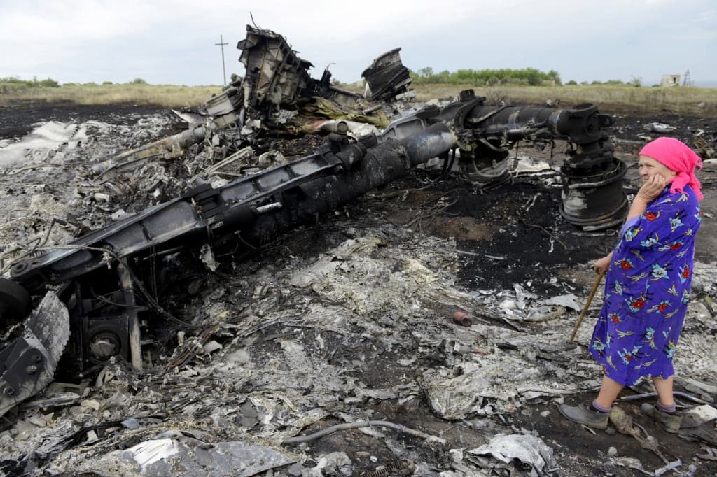 Um morador local está entre os destroços no local da queda da aeronave MH17 da Malaysia Airlines, transportando 298 pessoas de Amsterdã para Kuala Lumpur, em Grabove, no leste da Ucrânia