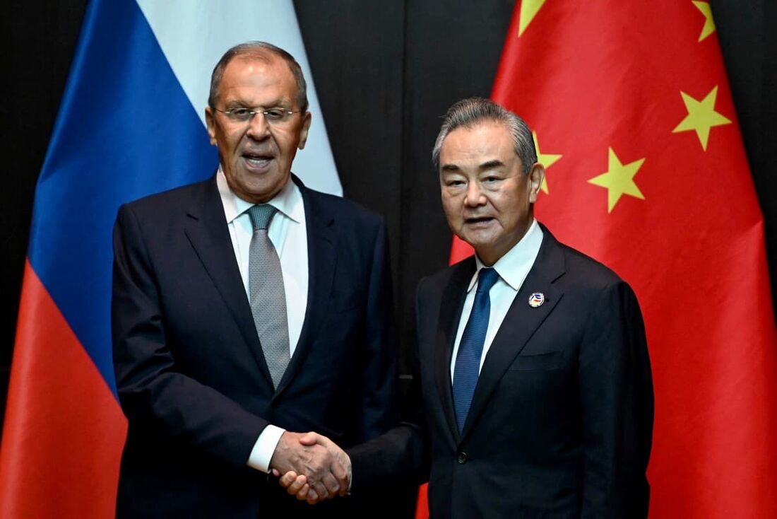  O Ministro das Relações Exteriores da China, Wang Yi (D), aperta a mão do Ministro das Relações Exteriores da Rússia, Sergei Lavrov