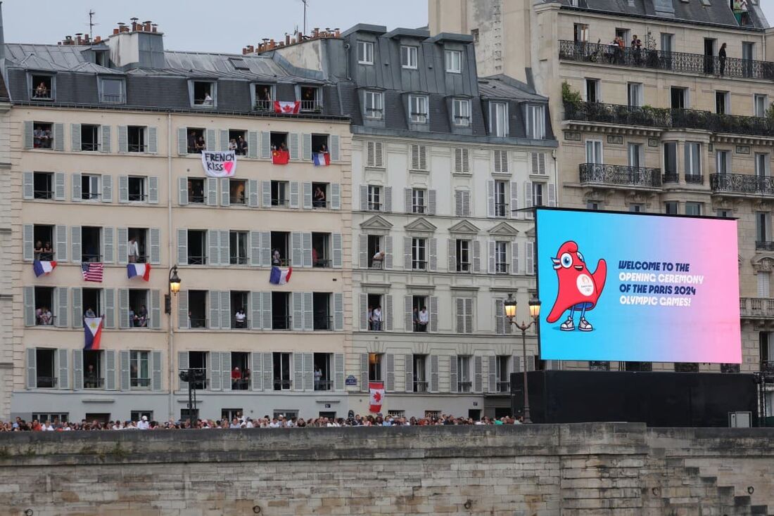 Nativos e turistas comparecem ao início da cerimônia de abertura dos Jogos Olímpicos de Paris 2024 em Paris, em 26 de julho de 2024. 