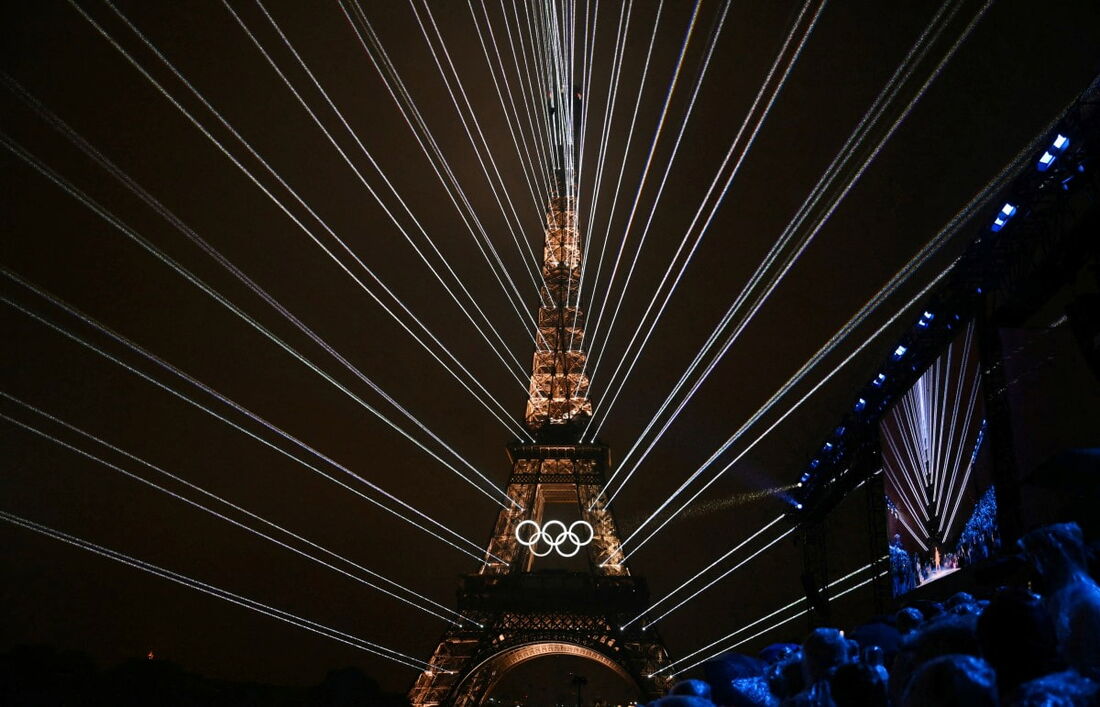 Torre Eiffel e dos lasers iluminando o céu, durante a cerimônia de abertura dos Jogos Olímpicos de Paris 2024