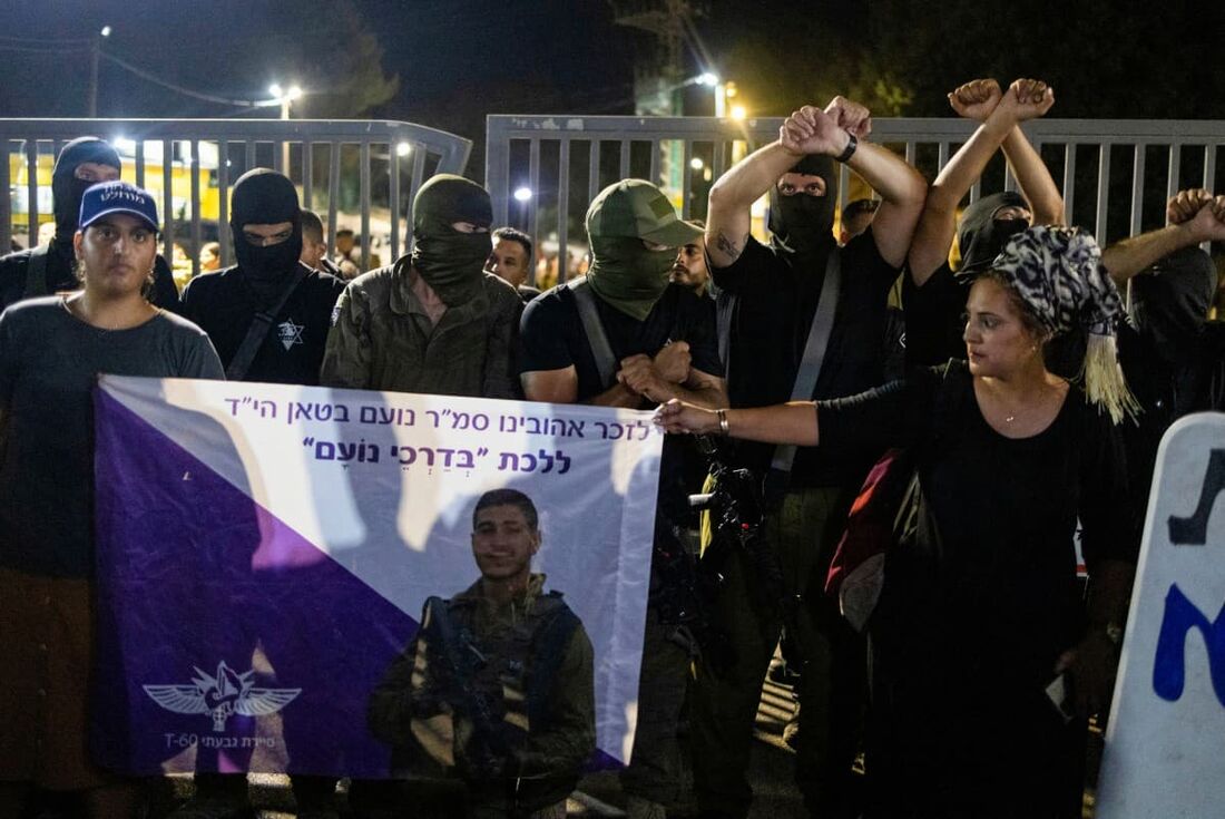 Manifestantes israelenses de direita, se reúnem do lado de fora da base militar de Bayt Lid enquanto protestam contra a detenção para interrogatório de reservistas militares