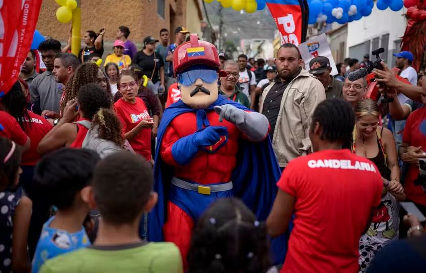 Homem vestido como 'Super Bigode', personagem do presidente venezuelano Nicolás Maduro, dança em comício em Caracas 