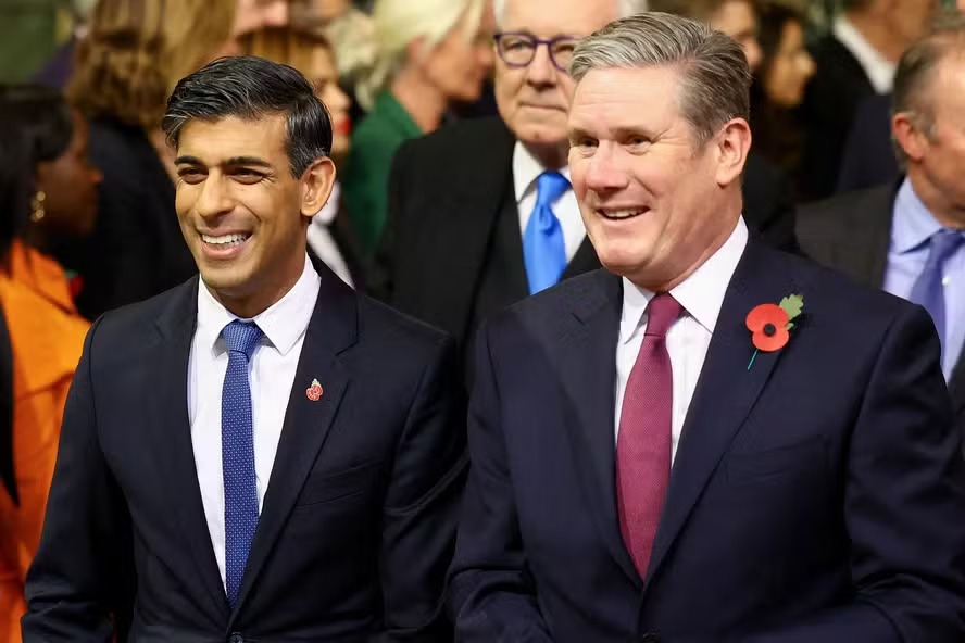 Rishi Sunak e Keir Starmer fotografados lado a lado no salão de entrada da Câmara dos Comuns, em 2023 