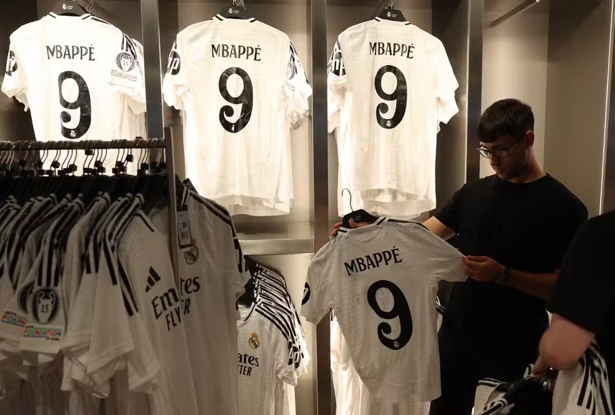 Fã observa camisa do Real Madrid com nome de Kylian Mbappé 