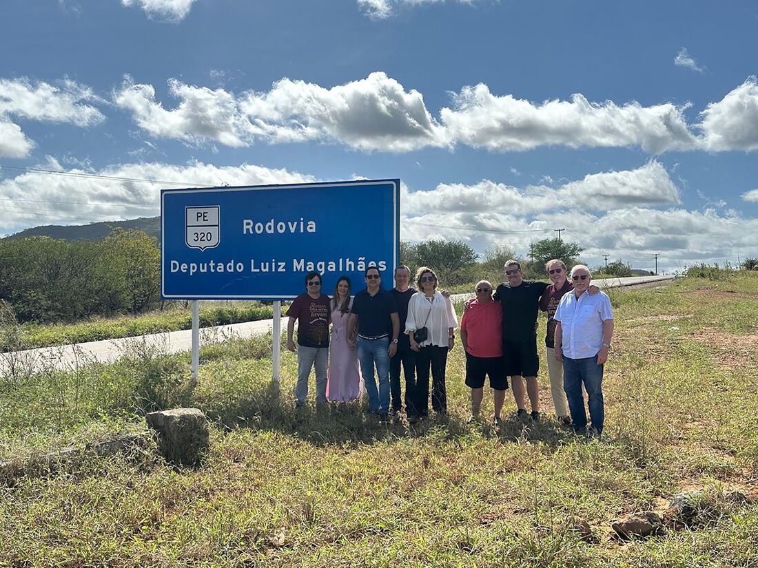 Eduardo Monteiro, Evandro Magalhães e a noiva, Ana Santos, posam para foto em frente à placa da Rodovia Deputado Luiz Magalhães com alguns primos e amigos do setor empresarial