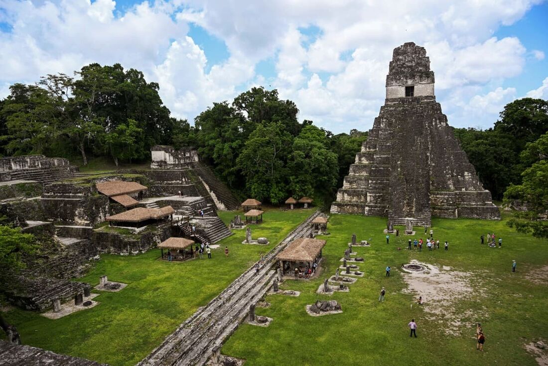 Turistas caminham em frente ao templo maia "Gran Jaguar" (Grande Jaguar) no sítio arqueológico de Tikal, na Biosfera Maia em Peten, Guatemala