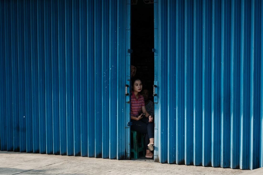 Uma mulher observa manifestantes indonésios se juntando a uma manifestação pró-palestina em frente à embaixada dos EUA em Jacarta