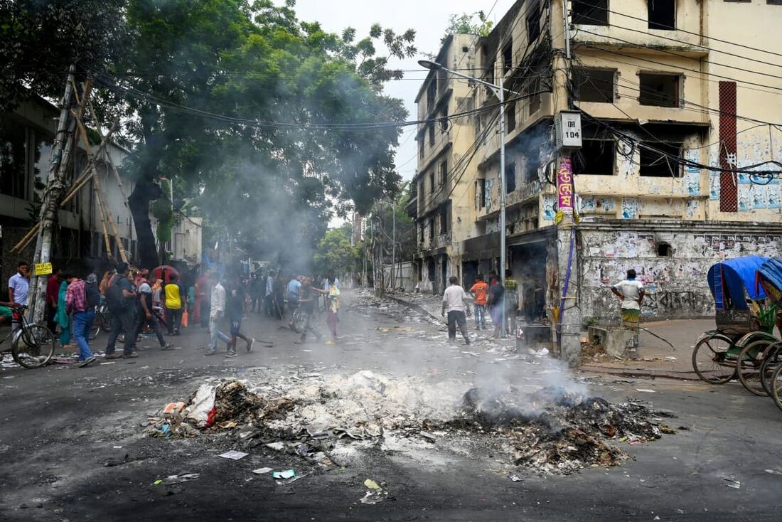 Manifestantes antigovernamentais ateiam fogo perto do escritório queimado do partido Awami League, depois que a ex-primeira-ministra Sheikh Hasina fugiu do país.