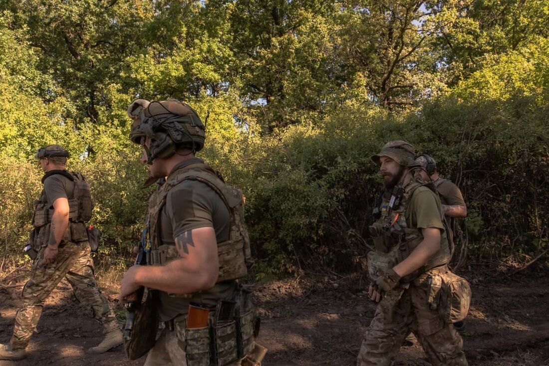 Soldados ucranianos caminham em uma área não revelada, no distrito de Pokrovsk, na região oriental de Donetsk, em meio à invasão russa da Ucrânia.