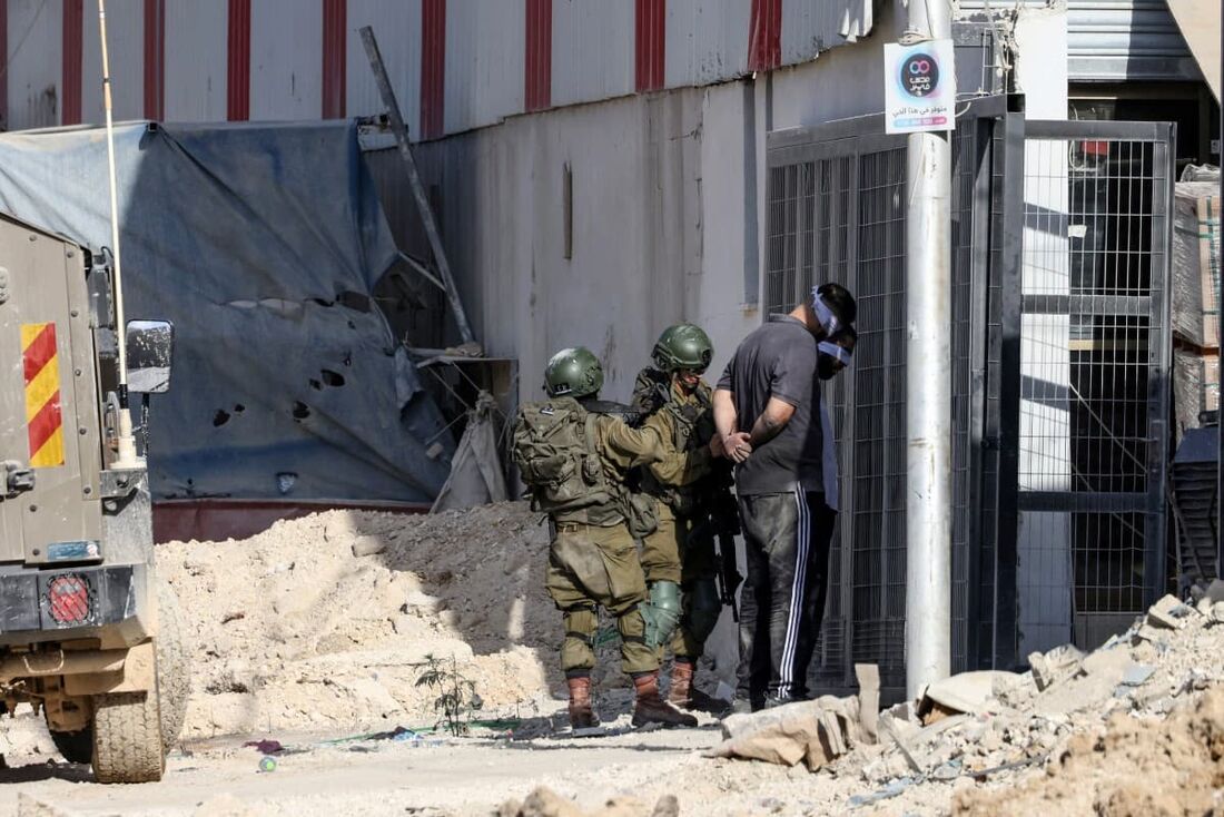 Soldados israelenses prendem dois homens palestinos durante uma operação no campo de Nur Shams, perto da cidade de Tulkarem, na Cisjordânia ocupada por Israel