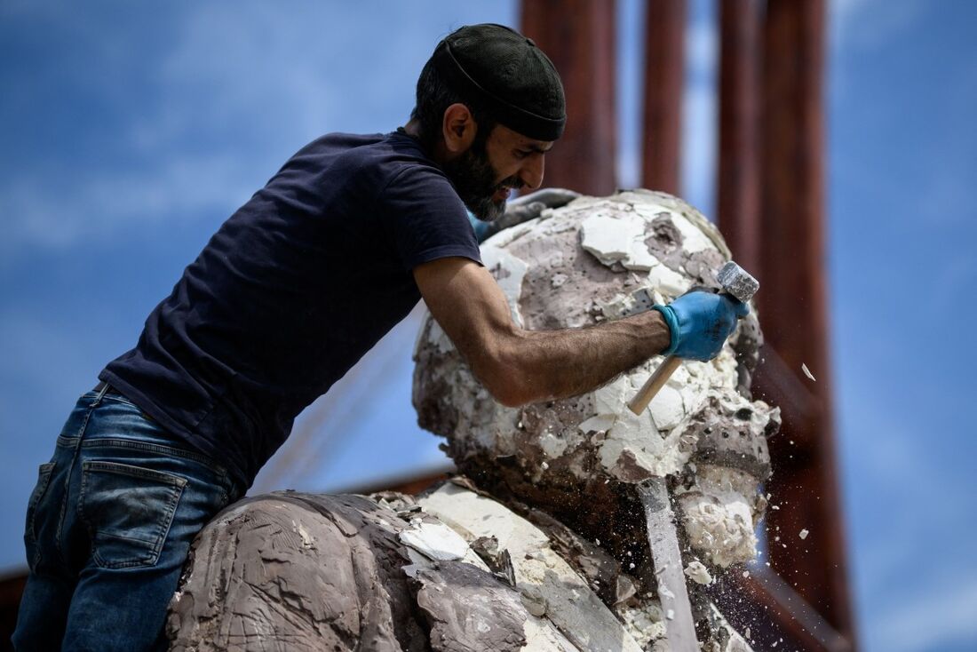 O escultor sírio exilado Khaled Dawwa destrói sua gigantesca obra de arte "O Rei dos Buracos", representando um potentado com um corpo enorme, para encenar um protesto por ocasião do Dia Internacional dos Desaparecidos, em frente aos escritórios das Naçõe