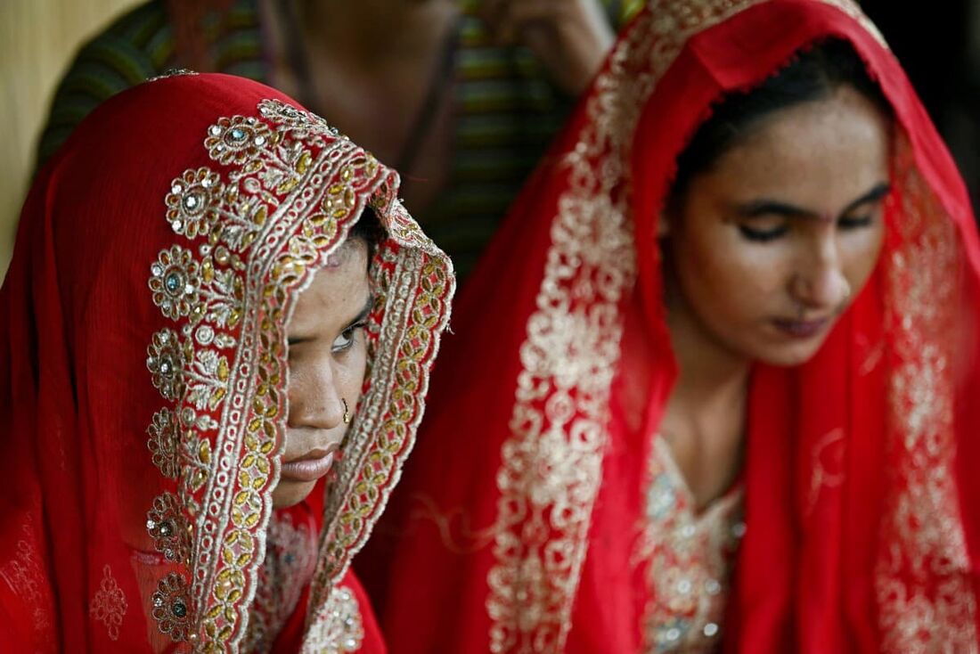 Nesta fotografia tirada em 3 de agosto de 2024, Shamila (E) e Salma Zameer, noivas das monções que se casaram menores de idade, olham para a vila de Khan Muhammad Mallah, distrito de Dadu, na província de Sindh