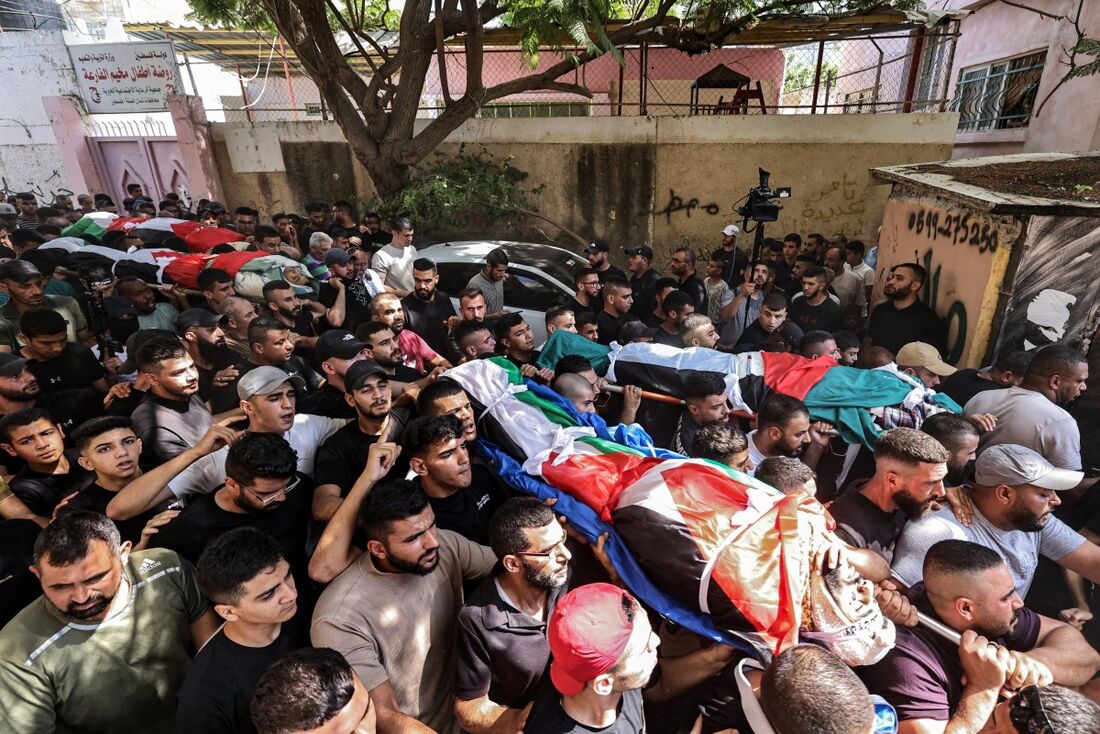 Os enlutados marcham com os corpos de quatro palestinos que foram mortos em uma operação militar israelense durante seu funeral no campo de Fara para refugiados palestinos perto de Tubas, no norte da Cisjordânia ocupada.