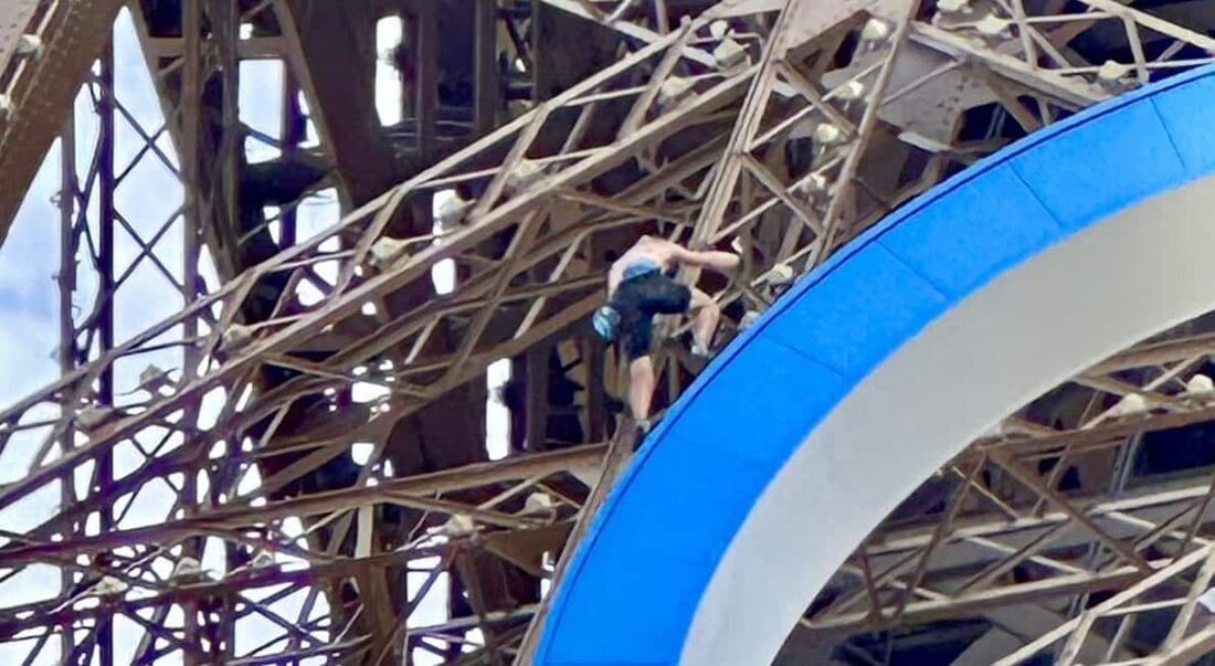 Homem escala Torre Eiffel, em Paris 