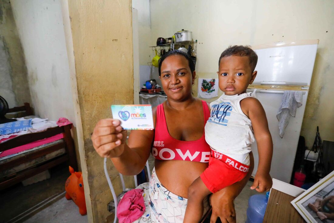 Mães de Pernambuco: mãe segura filho e cartão do programa