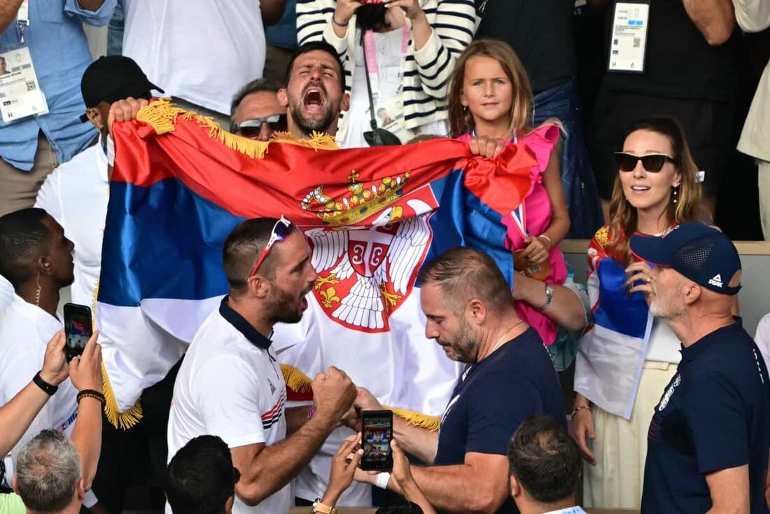 Empunhando a bandeira da Sérvia, Novak Djokovic comemora a vitória junto com a família