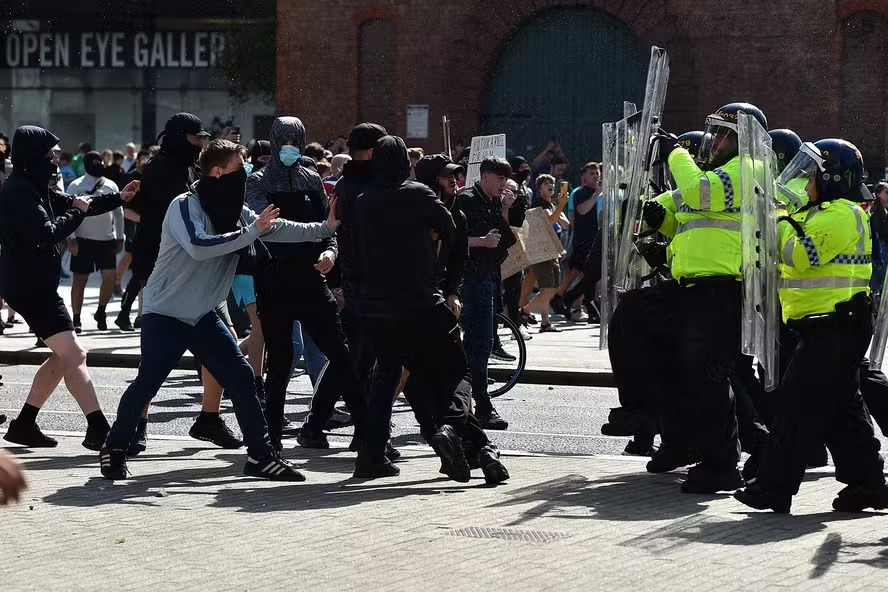 Policiais enfrentam manifestantes em Liverpool, no Reino Unido, em meio aos protestos violentos que se espalham pelo país