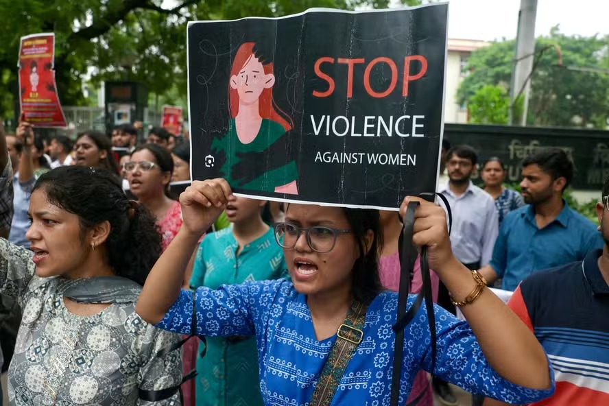 Protestantes levam cartazes a rua pedindo para cessar violência contra mulheres na Indía após caso de estupro e assassinato de médica 