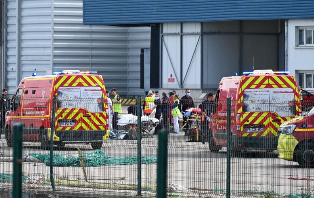 Bombeiros manuseiam os corpos de migrantes que morreram tentando cruzar o Canal para a Inglaterra em Boulogne-sur-Mer, norte da França