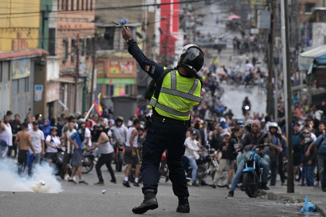 Um policial de choque usa gás lacrimogêneo contra manifestantes durante um protesto de opositores ao governo do presidente venezuelano Nicolás Maduro no bairro de Catia, em Caracas