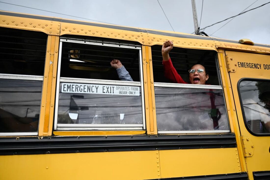 Prisioneiros políticos nicaraguenses libertados acenam ao partir em um ônibus após sua chegada à Base Aérea da Cidade da Guatemala em 5 de setembro de 2024.