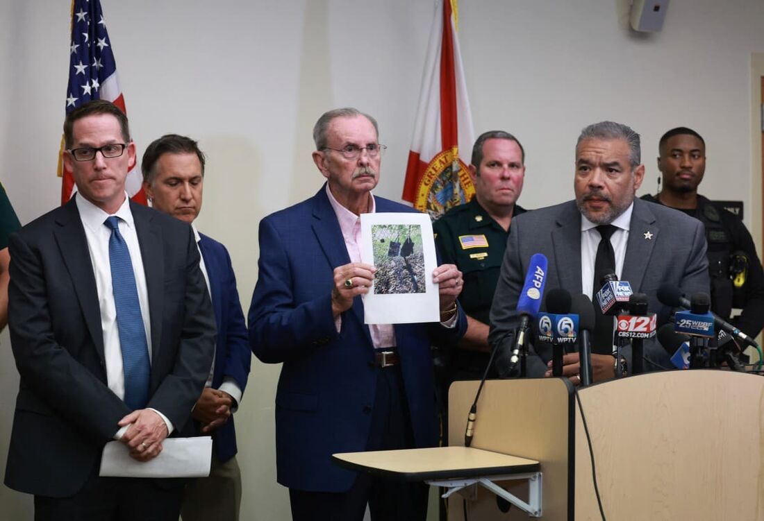 Xerife do condado de Palm Beach, Ric Bradshaw (C), segura uma fotografia do rifle e outros itens encontrados no entorno dos disparos