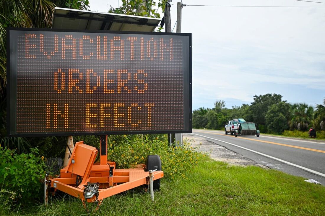 Uma placa exibe ordens de evacuação enquanto os preparativos são feitos para a chegada do furacão Helene, em Cedar Key, Flórida