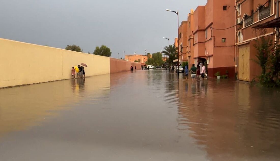 Moradores caminham em uma rua inundada na cidade de Ouarzazate, no Marrocos