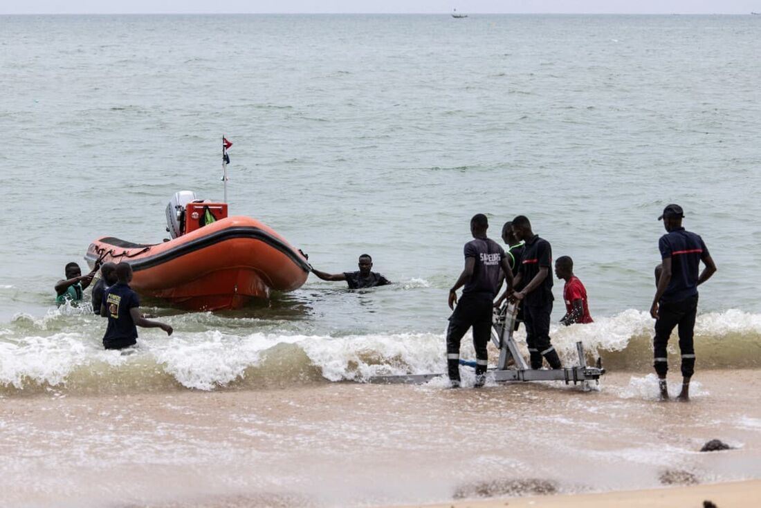 Membros de uma equipe de busca e resgate seguem para a costa durante uma busca para encontrar sobreviventes e resgatar os mortos depois que uma piroga transportando mais de cem migrantes afundou na noite anterior