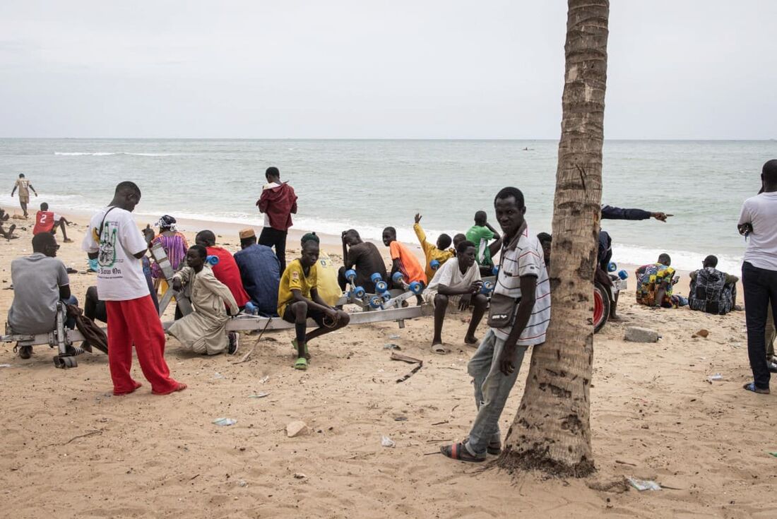 Familiares, amigos e membros da comunidade se reúnem ao longo da praia enquanto esperam que as equipes de busca e resgate encontrem sobreviventes e recuperem os mortos depois de naufrágio