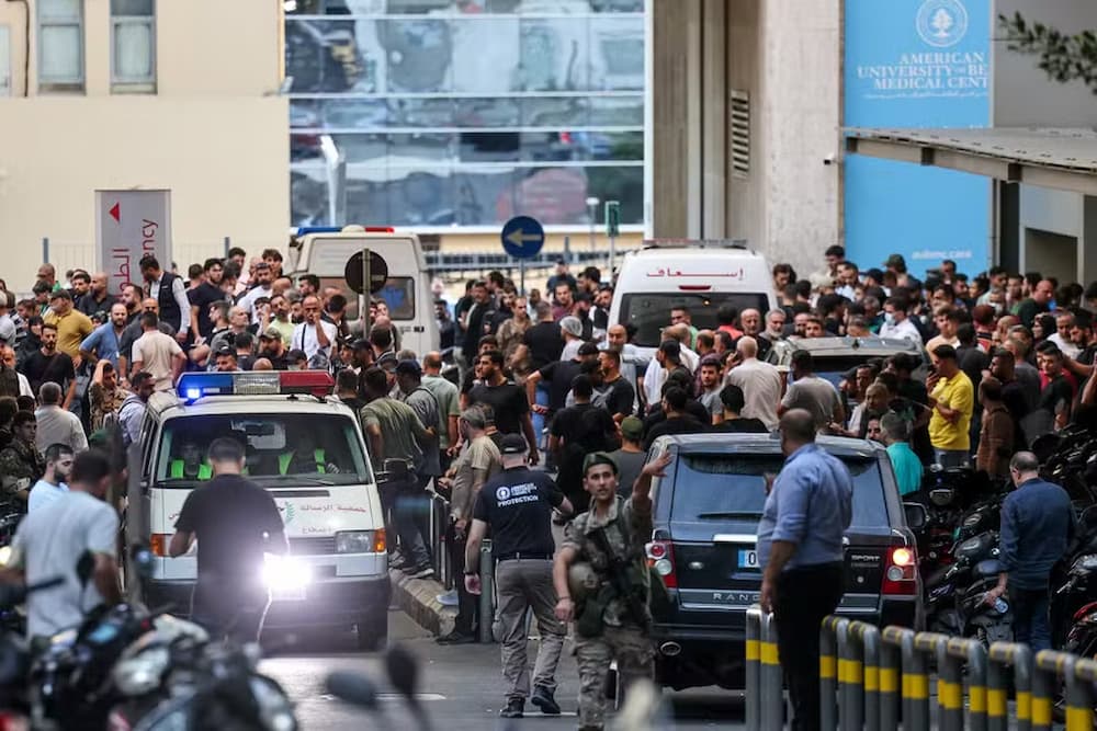 Ambulâncias são cercadas por pessoas na entrada do Centro Médico da Universidade Americana de Beirute, em 17 de setembro de 2024, após explosões atingirem locais em vários redutos do Hezbollah